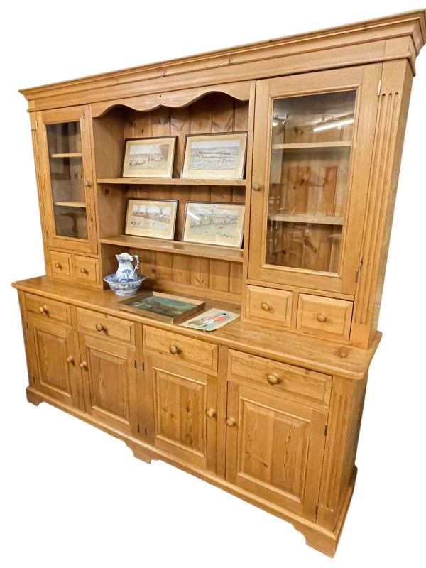 Large pine dresser, the upper section with two central shelves flanked by two glazed cupboard doors above four spice drawers, the base with four drawers above four cupboard doors, 213.5cm by 226cm by 50cm.