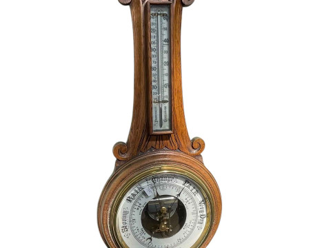 Carved oak aneroid barometer.