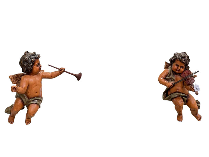 Two painted cupids wall hangings.
