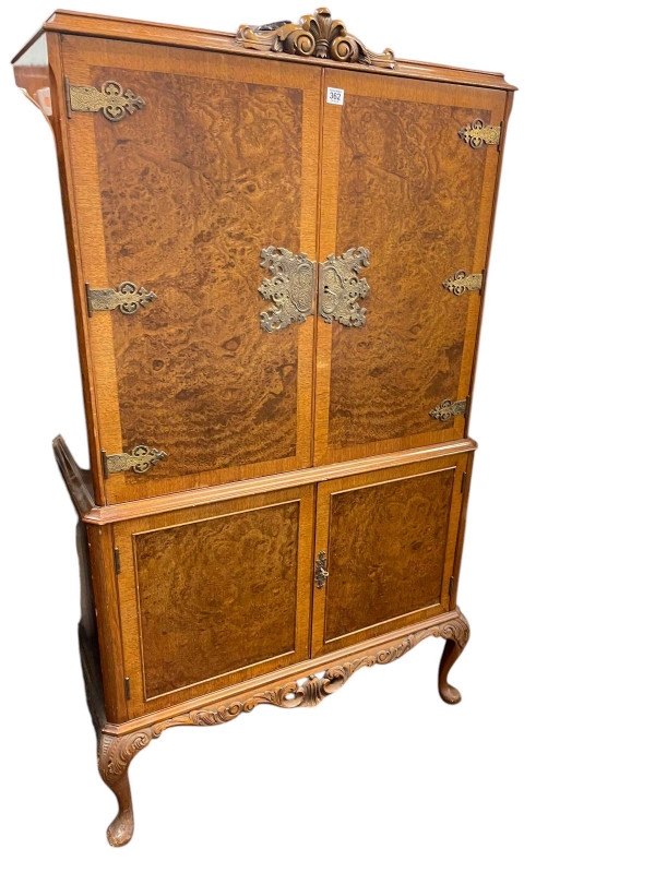 WITHDRAWN         Burr walnut four door cocktail cabinet on cabriole legs, 156cm by 94cm by 45cm.