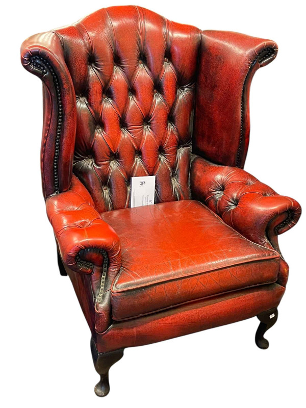 Ox blood buttoned leather and studded wing back armchair.