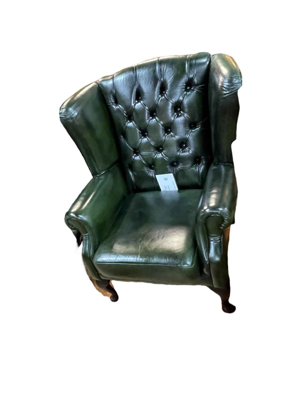 Green button backed leather wing armchair.