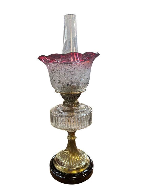 Victorian brass oil lamp with clear glass reservoir and ruby shade, and oak barometer.
