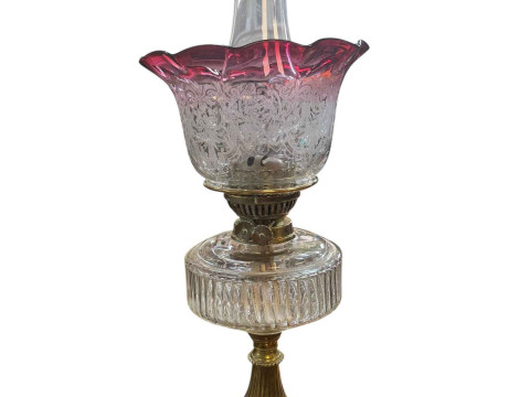 Victorian brass oil lamp with clear glass reservoir and ruby shade, and...