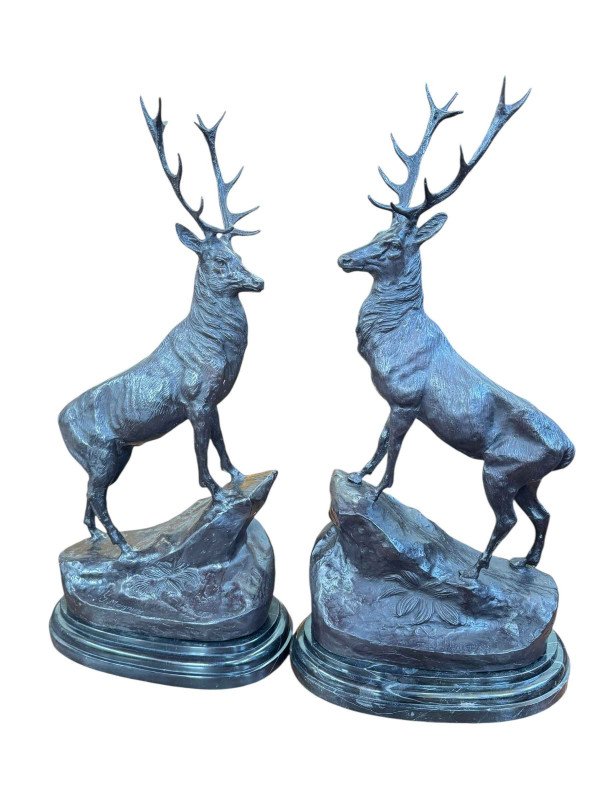 Pair of impressive bronze stags on rocky outcrops raised on marble plinths, 75cm.