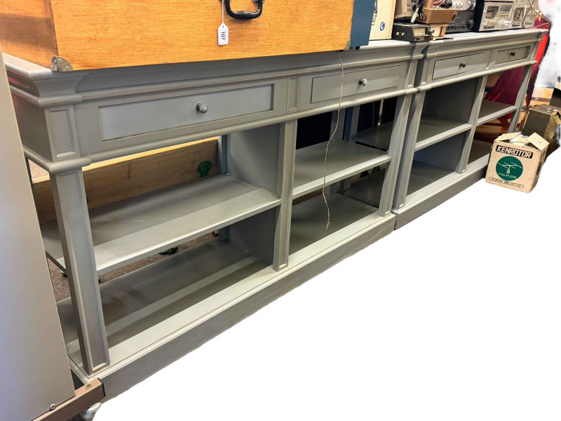 Pair grey painted double sided console tables having two drawers above four open sections, 90.5cm by 160cm by 43cm.