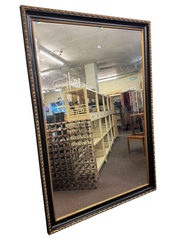 Large black and gilt framed bevelled wall mirror, 203cm by 141cm including frame.