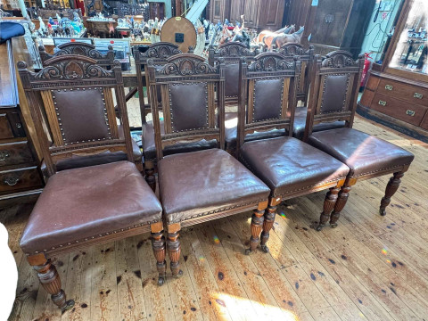 Set of eight Victorian carved mahogany dining chairs in buttoned hide.