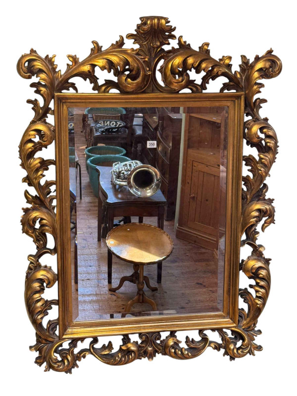 Gilt framed Rococo style bevelled wall mirror, 120cm by 87cm.