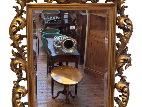 Gilt framed Rococo style bevelled wall mirror, 120cm by 87cm.
