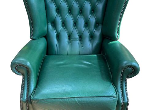 Green buttoned leather and studded wing back reclining armchair.