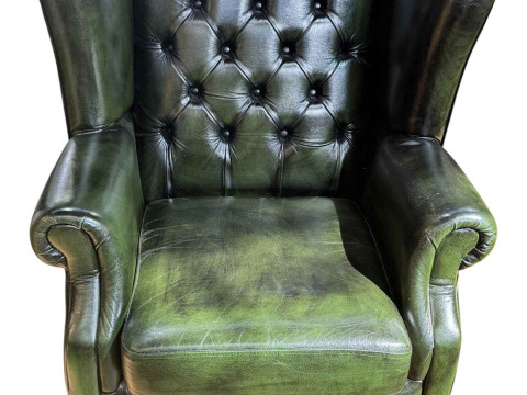 Green button backed leather wing armchair.