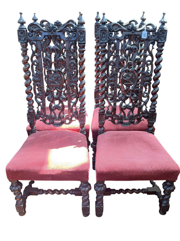 Set of four carved oak high back dining chairs with twist supports.
