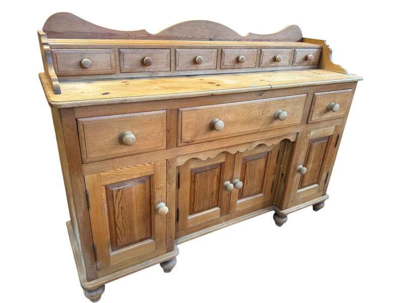 Pine dresser having six upper spice drawers above a base of three drawers and four cupboard doors, 115cm by 157.5cm by 48cm.