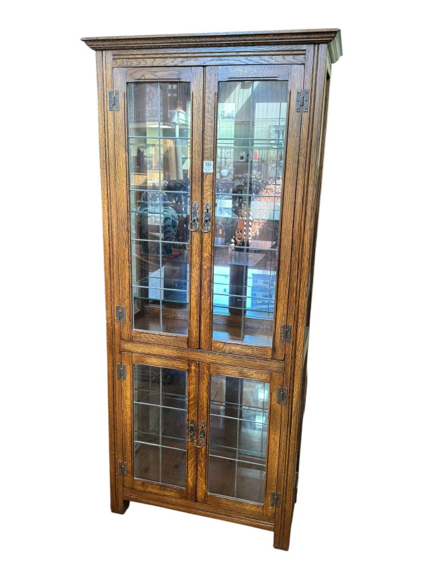Oak display cabinet having four leaded glazed panel doors, 178cm by 80cm by 37cm.