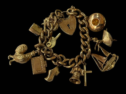 9 carat gold charm bracelet with eleven gold charms and padlock fastener.