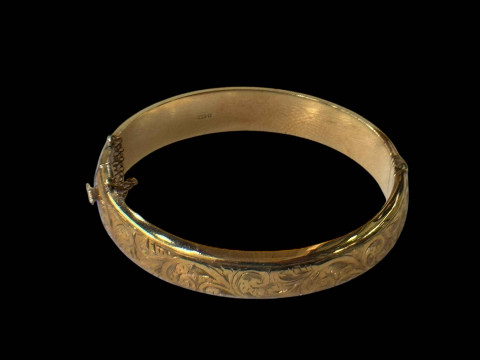 9 carat gold hinged bangle with half engraved scrolls.