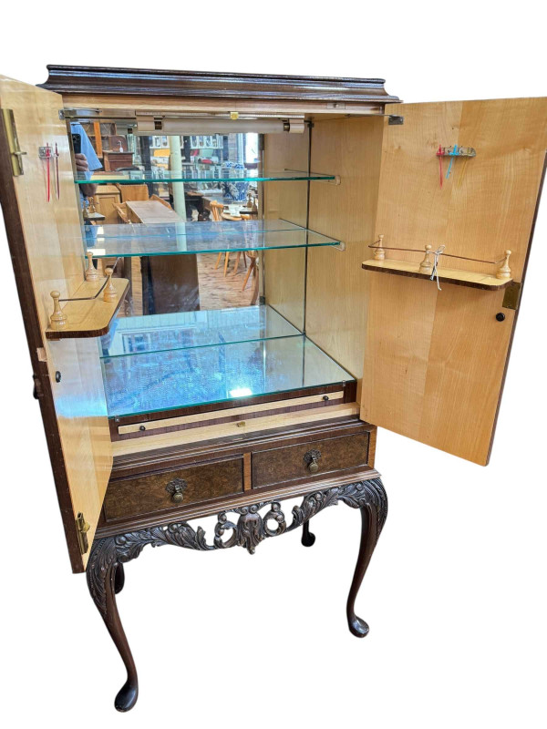 Burr walnut cocktail cabinet having two doors above two drawers on cabriole legs, 152.5cm by 77cm by 49cm.