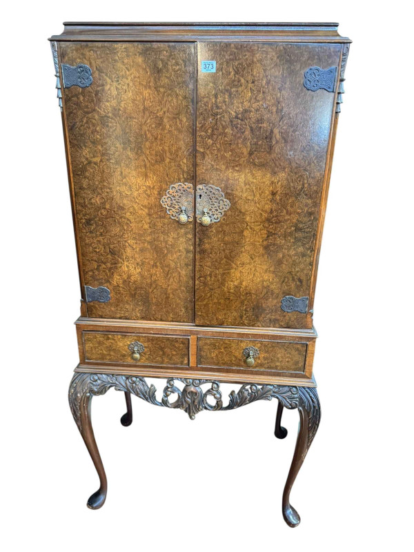 Burr walnut cocktail cabinet having two doors above two drawers on cabriole legs, 152.5cm by 77cm by 49cm.