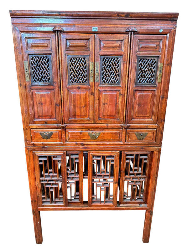 Chinese lacquered wedding cabinet having four fretwork panel doors above three drawers with four sliding fretwork doors below, 179.5cm by 100.5cm by 57cm.