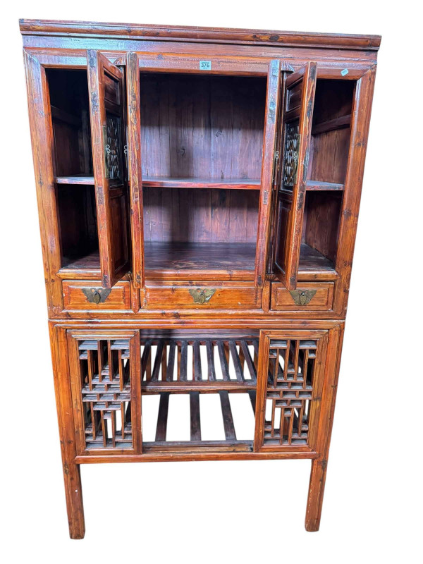 Chinese lacquered wedding cabinet having four fretwork panel doors above three drawers with four sliding fretwork doors below, 179.5cm by 100.5cm by 57cm.