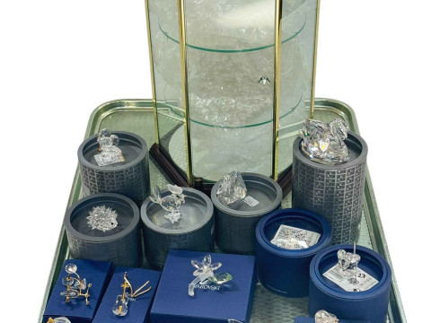 Collection of boxed Swarovski ornaments and hexagonal display cabinet.
