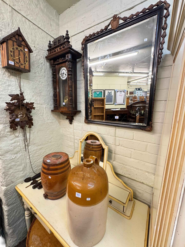 Oval walnut pedestal coffee table, framed bevelled wall mirror, Victorian wall clock, two cuckoo clocks and stone bottle and barrel (7).