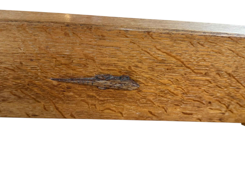 Derek 'Lizardman' Slater rectangular adzed oak coffee table raised on tapered end supports joined by a stretcher, 49cm by 79cm by 40cm.