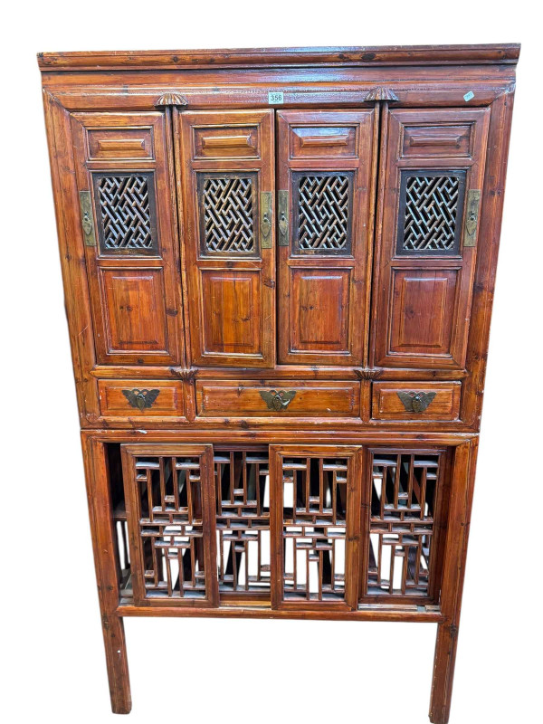 Chinese lacquered wedding cabinet having four fretwork panel doors above three drawers with four sliding fretwork doors below, 179.5cm by 100.5cm by 57cm.