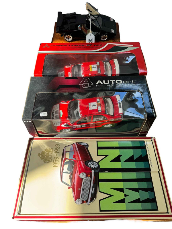 Four boxed model vehicles including two Tommi Mäkinen Mitsubishi Lancers, Burago Lamborghini Countach and Corgi Mini 1959-1989.