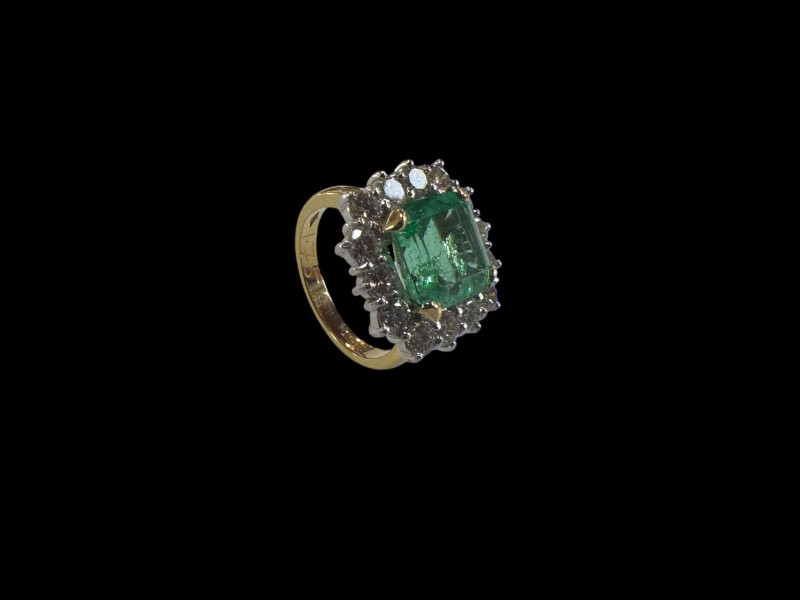Good quality natural emerald and diamond cluster ring set in 18 carat white gold with yellow shank, size Mœ, with diamond grading report.