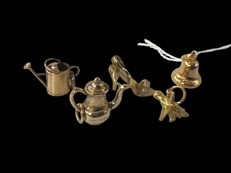 Five 9 carat yellow gold charms, bell, watering can, coffee pot, ladies shoe and bird on a swing.