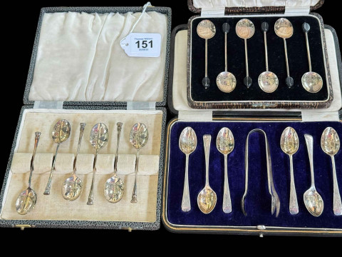 Three cased sets of silver coffee and teaspoons.