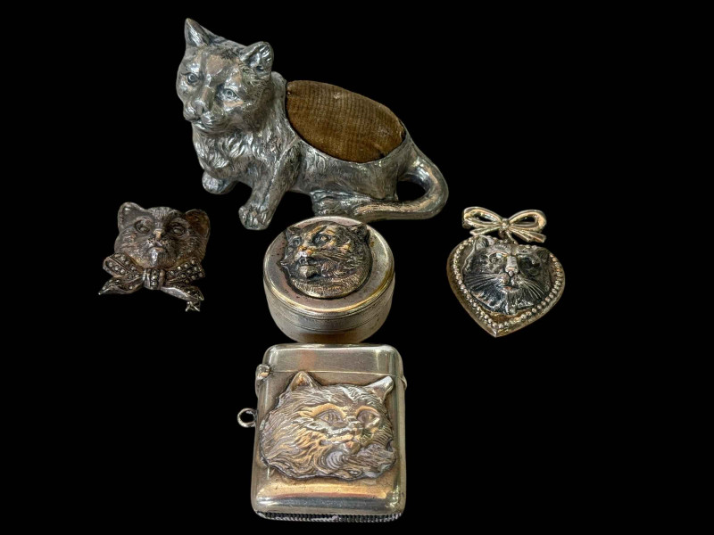 Edwardian silver cat vesta case, Chester 1904, two silver cat brooch and pendant, and plated pill box and pin cushion (5).