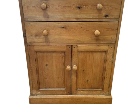 Pine cupboard having two long drawers above a pair of panelled doors,...