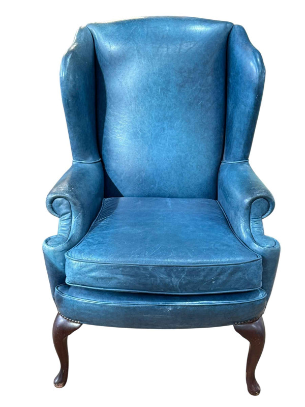 Blue leather and studded wing back armchair on cabriole legs.