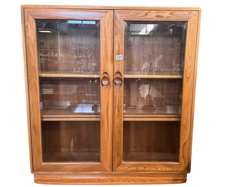 Ercol Windsor cabinet having two door display above a base of two drawers with two cupboard doors below, 166cm by 91cm by 44cm.