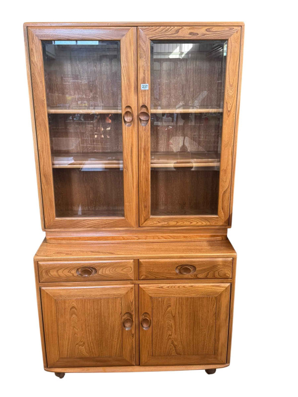 Ercol Windsor cabinet having two door display above a base of two drawers with two cupboard doors below, 166cm by 91cm by 44cm.