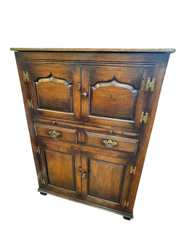 Titchmarsh & Goodwin? oak four door drinks cabinet having slide above two drawers, 130cm by 91.5cm by 46cm.