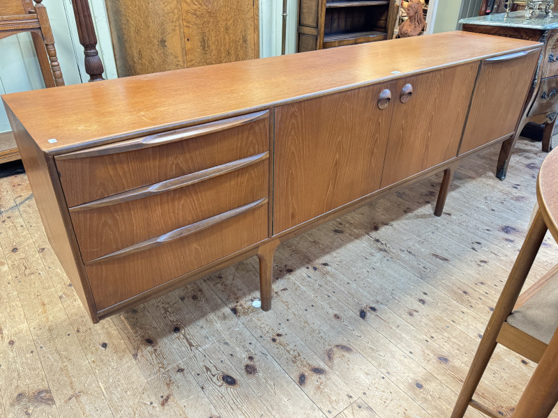 Mid Century A H McIntosh & Co teak six piece dining suite comprising Long John sideboard, 75cm by 213.5cm by 47cm, circular extending dining table with integral leaf, 74cm by 122cm dia. (excluding leaf) and set of four space saver chairs.