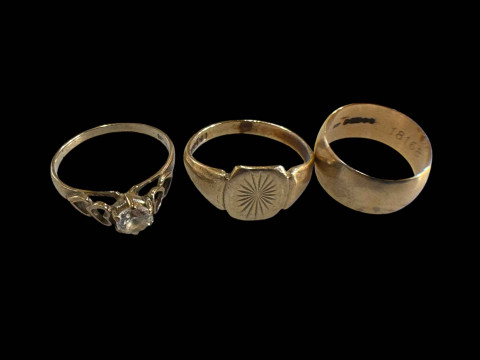 9 carat gold wedding band and two 9 carat gold rings, one gem set (3).
