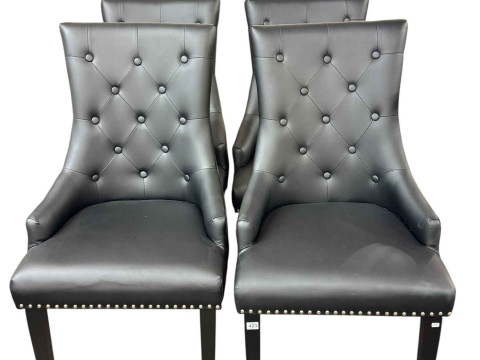 Set of four black buttoned faux leather contemporary dining chairs.