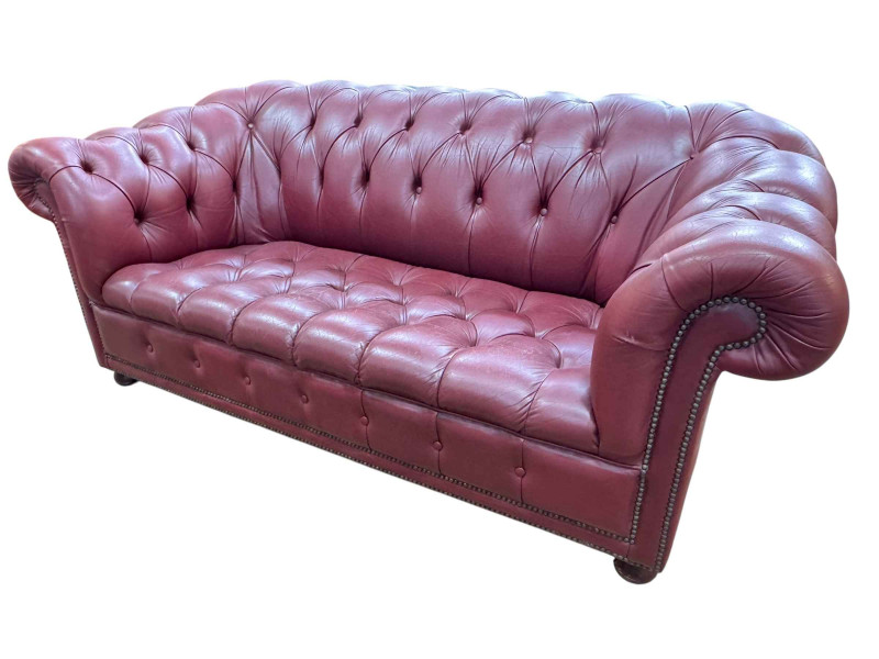 Cherry red all buttoned leather and studded two seater Chesterfield settee, 77cm by 182cm by 90cm.