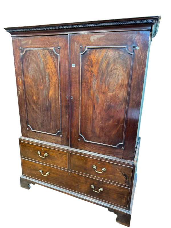19th Century mahogany gents wardrobe having two doors above two short and one long drawer on bracket feet, 177cm by 134cm by 62cm.