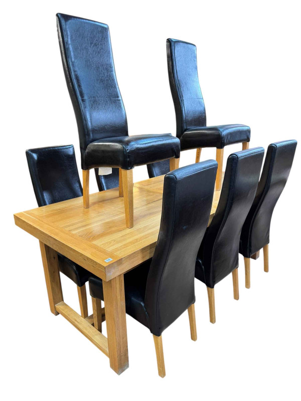 Contemporary light oak eleven piece dining suite comprising three door sideboard, wall mirror, rectangular extending dining table with two integral leaves and set of eight faux leather high back dining chairs.