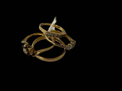 Four 9 carat and unmarked rings, one band the others gem set.