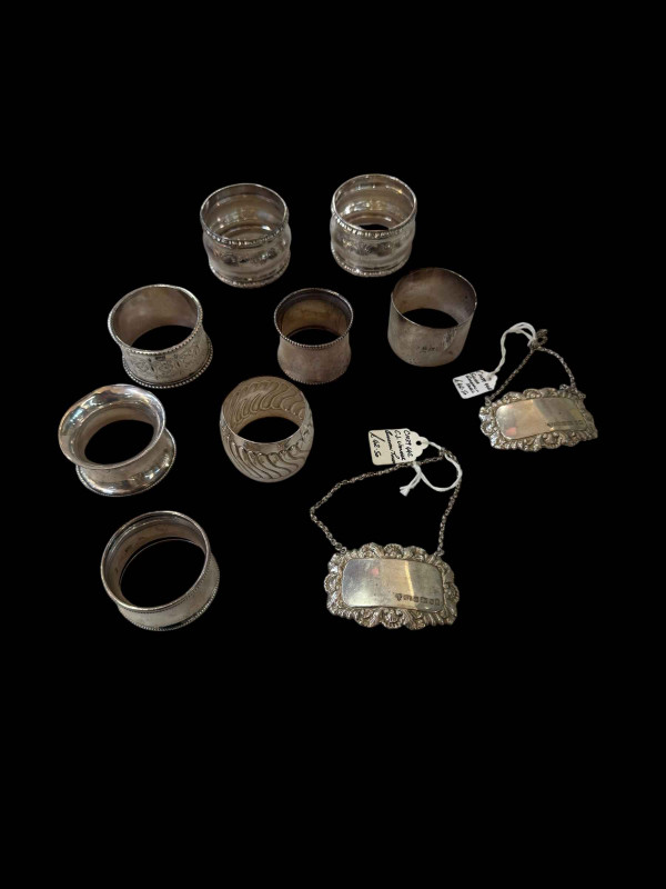 Collection of eight silver napkin rings and two silver decanter labels (8).