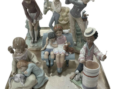 Five Lladro figures including male and female golfers and similar group...