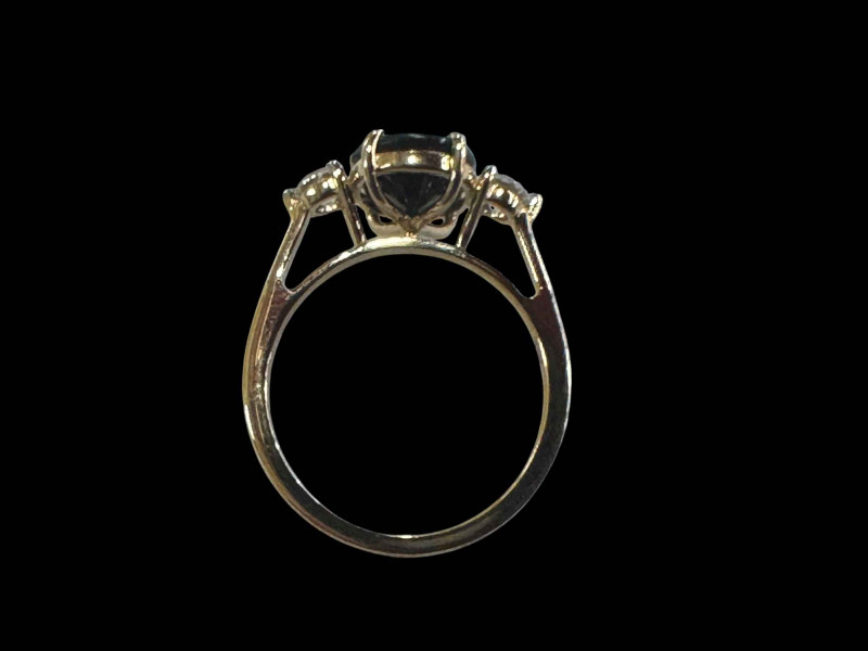 Three stone sapphire and diamond ring, the central oval sapphire 3.40 carats flanked by round brilliant cut diamonds totalling 0.37 carats, set in yellow gold, size M.