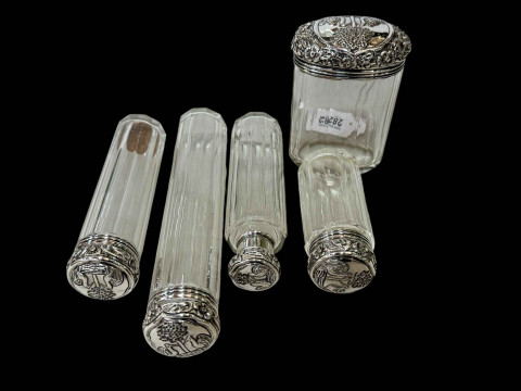 Five silver topped toilet bottles, London 1909.